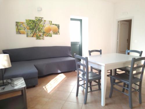 sala de estar con sofá, mesa y sillas en Sea Breeze House, en Amalfi