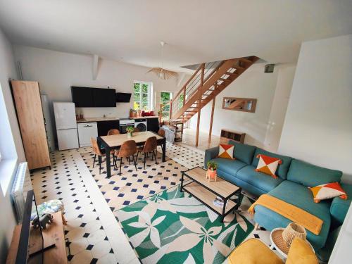 a living room with a blue couch and a table at La maison du bien-être 