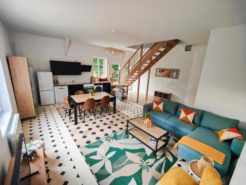 a living room with a blue couch and a table at La maison du bien-être in Le Bois-Robert