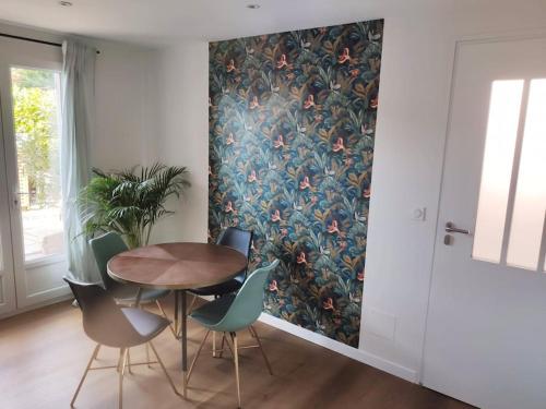 a dining room with a table and chairs with a wallpaper at Appartement duplex avec terrasse in Venelles