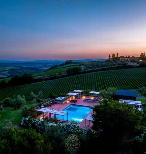 an aerial view of a villa with a pool in a vineyard at Locanda Le Piazze in Castellina in Chianti