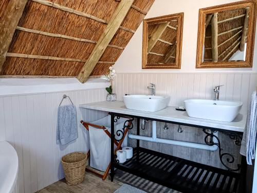 2 lavabos en un baño con techos de madera en Sedgefield Lodge, en Witbank