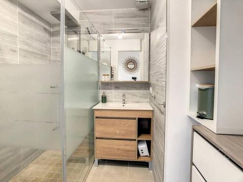 La salle de bains est pourvue d'un lavabo et d'une douche. dans l'établissement Le Canal - Appartement avec vue 4 personnes, à Laredorte