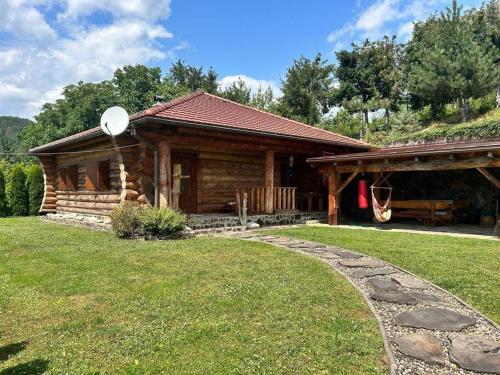 une cabane en rondins avec un chemin en pierre en face de celle-ci dans l'établissement Ultimate relaxation near Slovak Paradise, à Rožňava