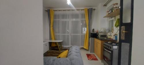 een woonkamer met een bank en een keuken bij Beta Two Apartment in Nairobi