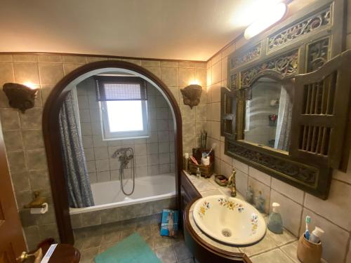 a bathroom with a tub and a sink and a mirror at Greek Tuscany Vasiliki's Home in Aigio
