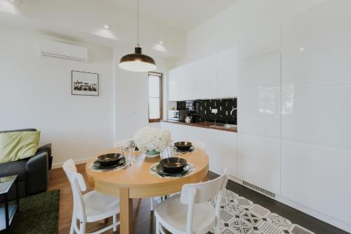 a kitchen and dining room with a wooden table and chairs at Aura Medical SPA Nałęczów in Nałęczów