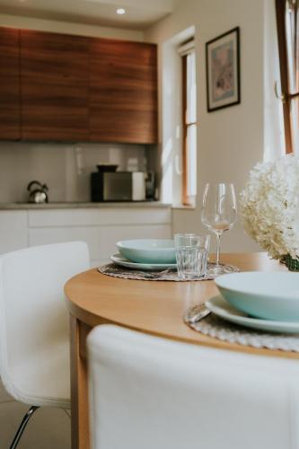 a kitchen with a table with plates and wine glasses at Aura Medical SPA Nałęczów in Nałęczów