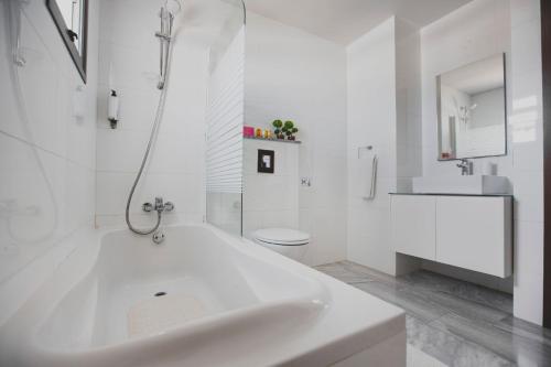 a white bathroom with a sink and a toilet at Latchi Escape Hotel and Suites - By IMH Travel & Tours in Neo Chorio
