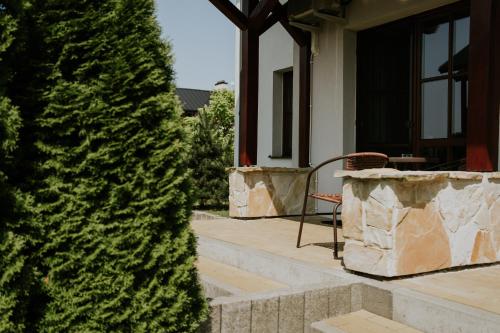 a chair on a porch next to a tree at Aura Medical SPA Nałęczów in Nałęczów