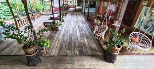 a wooden floor with potted plants on a porch at TA YAI HOMESTAY (ตา ยาย โฮมสเตย์) in Ko Kood