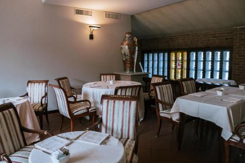 a restaurant with tables and chairs with white tablecloths at Il Castello Di San Gaudenzio in Cervesina