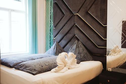 a bedroom with a bed with a wooden headboard at Belvedere Apartment in Vienna