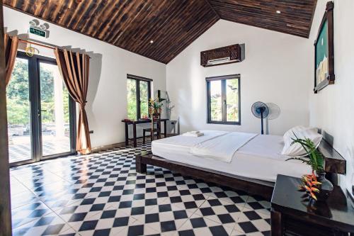 um quarto com uma cama e um piso em xadrez em Dong Giao Bungalows em Tam Ðiệp