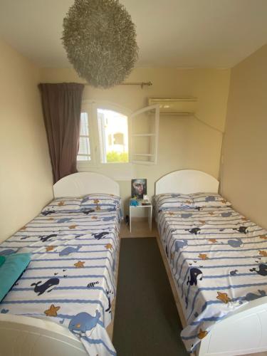 two beds in a small room with two beds sidx sidx sidx at Green leaves Challet North Coast k75 in Dawwār Muḩammad Abū Shunaynah