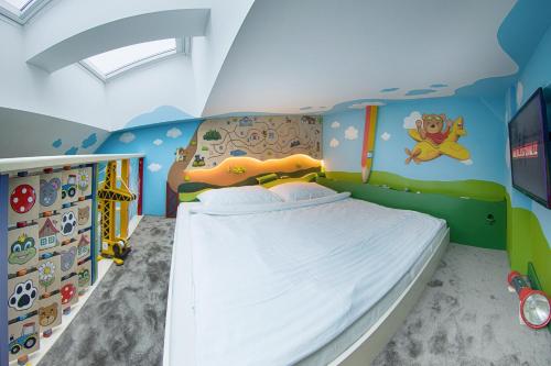 a bedroom with a bed in a room with a ceiling at Hotel Kocourkov in Hlinsko