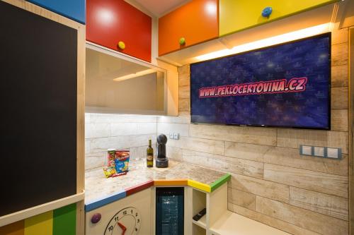 a kitchen with a tv on a wall at Hotel Kocourkov in Hlinsko