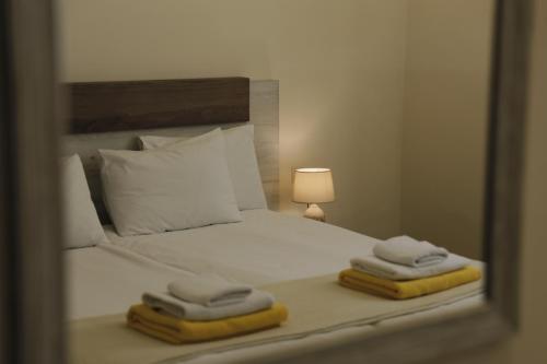 a mirror reflecting a bed with towels on it at OXYGEN Shekvetili in Shekvetili