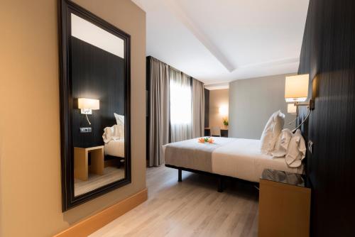 a hotel room with a bed and a mirror at Hotel Plaza in A Coruña