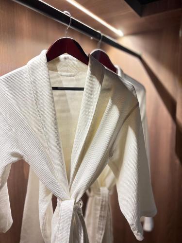 a white shirt on a hanger in a closet at Harmony Phnom Penh Hotel in Phnom Penh
