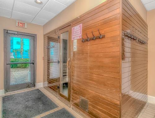 Zimmer mit einer Dusche und einer Holzwand in der Unterkunft The Palace 1702 in Myrtle Beach