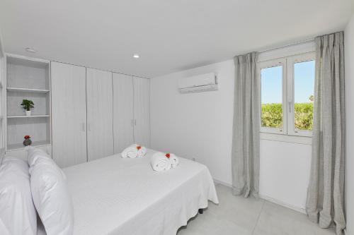 a white room with two beds and a window at Casa Do Levante3 Bedrooms With Sea View in Vila Nova de Cacela