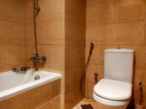 a bathroom with a toilet and a bath tub at Sea View Studio 3 Royal Breeze Breezeسي ويو ستوديو رويال بريز in Ras al Khaimah