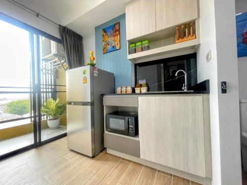 a kitchen with a refrigerator and a microwave at ABoutNont HOTEL & MANSION in Nonthaburi