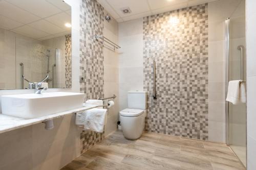 La salle de bains est pourvue d'un lavabo, de toilettes et d'une douche. dans l'établissement Hotel Ecoavenida, à Benicàssim