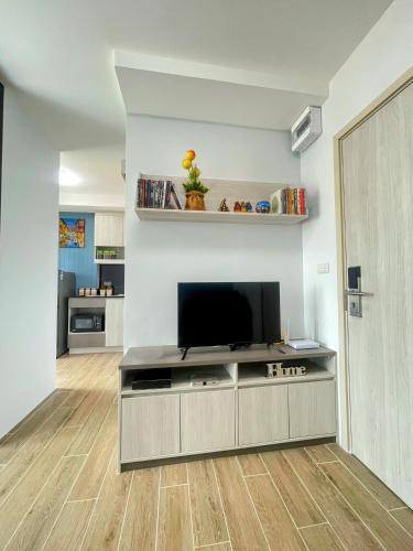 a living room with a flat screen tv on a wall at ABoutNont HOTEL & MANSION in Nonthaburi
