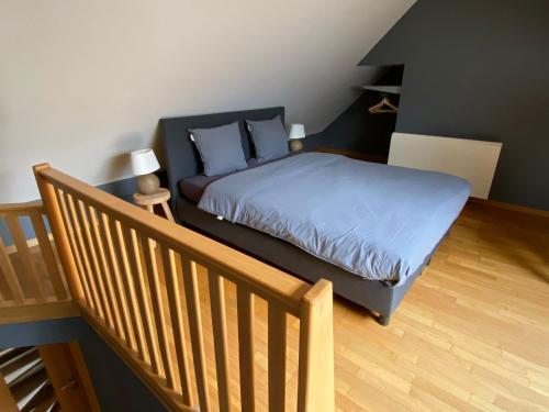 um quarto com uma cama com lençóis azuis e uma escada em Holiday-Home Maas&Mechelen em Maasmechelen