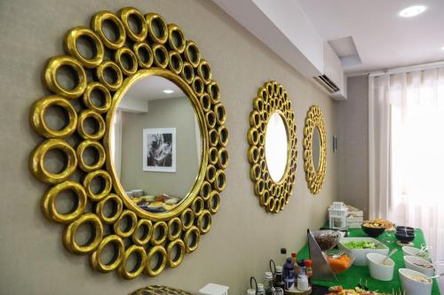 a dining room with a large gold mirror on the wall at Josefa D`Obidos Hotel in Óbidos