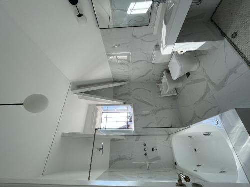 a white bathroom with a sink and a mirror at Casa Villa Julia in Tigre