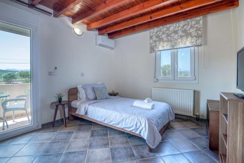 a bedroom with a bed and a balcony at Tonia's Residential Villa in Kissamos