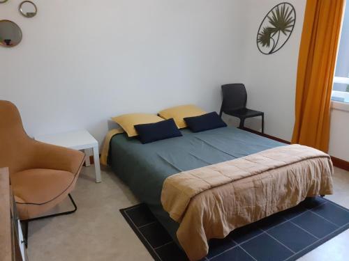 a bedroom with a bed and a chair in it at Le gîte blinois in Blain