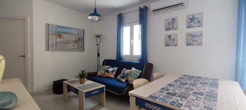 um pequeno quarto com uma cama e uma cadeira azul em Mar Salada em L'Ametlla de Mar