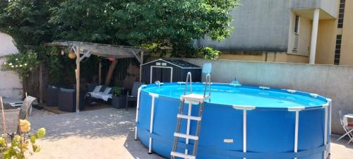- un bain à remous bleu dans une cour avec une cabane pour chiens dans l'établissement Studio pour location vacances a la semaine AVIGNON, à Avignon