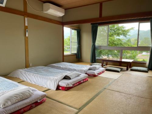 una camera da letto con due letti e una finestra di Togawaso a Fujikawaguchiko