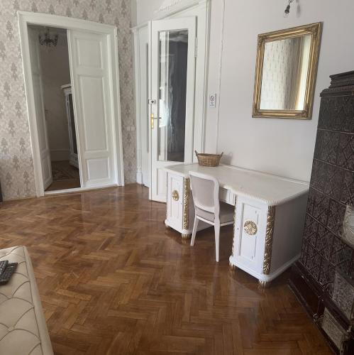 a living room with a white desk and a chair at Apartments & Room - Korzo in Sombor