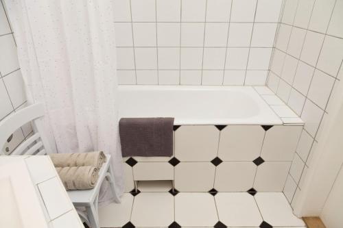 a white bathroom with a black and white tiled floor at Kurucz Apartman in Sárospatak