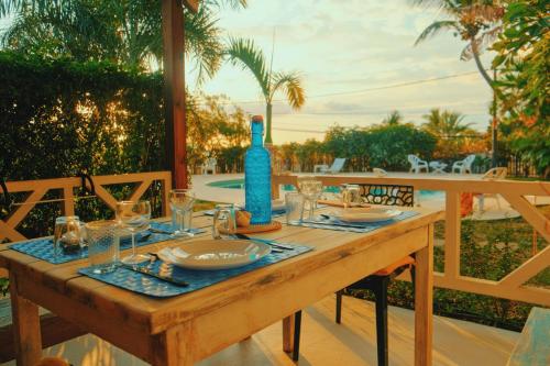 - une table en bois avec une bouteille bleue et des verres dans l'établissement LES PECHEURS DU LAGON, à Saint-Leu