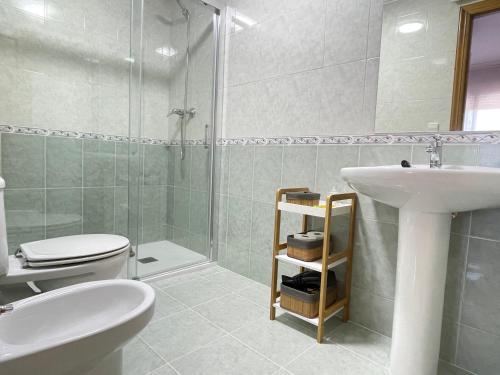 ein Bad mit einem Waschbecken, einem WC und einer Dusche in der Unterkunft Piso Sirius in Vilagarcia de Arousa