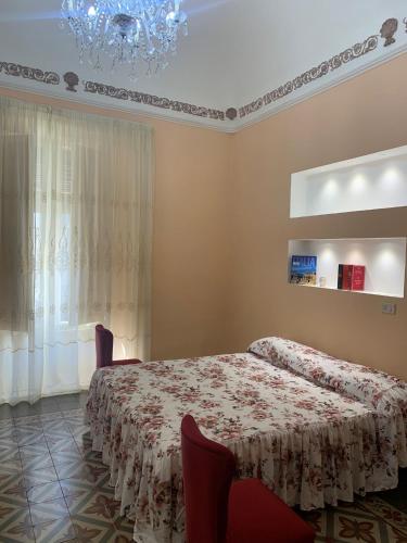 um quarto com uma cama e um lustre em Casa Vacanze Miriam em Randazzo