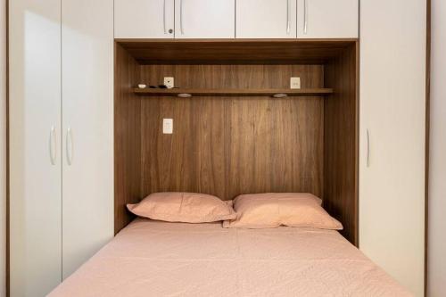 un letto con due cuscini in una piccola stanza di Apartamento 1 quarto a 4 min da praia - Copacabana a Rio de Janeiro