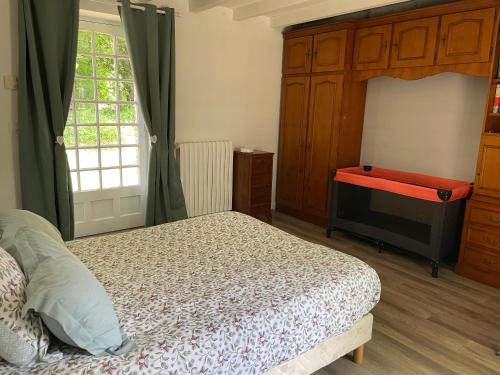 um quarto com uma cama e uma janela em La mission em Saint-Martin-des-Noyers