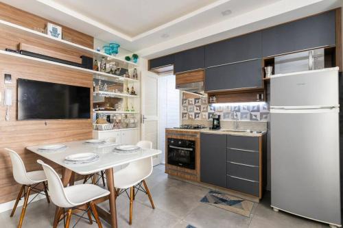 una cucina con tavolo e frigorifero bianco di Apartamento 1 quarto a 4 min da praia - Copacabana a Rio de Janeiro