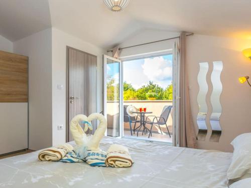 a bedroom with a bed with towels and a balcony at Villa Emili by IstriaLux in Svetvinčenat