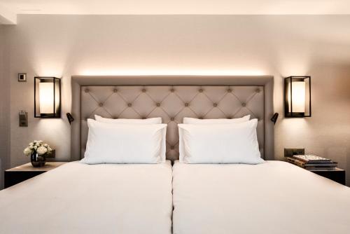 um quarto com uma grande cama branca e 2 almofadas em Hotel Astoria em Lucerna