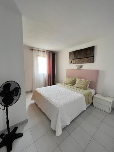 een witte slaapkamer met een bed en een raam bij Torres Del Sol , Las Americas , cute apartment in Arona