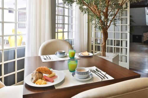 a table with two plates of food on it at Josefa D`Obidos Hotel in Óbidos